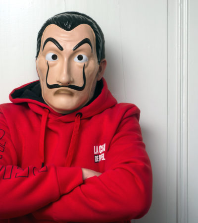 Mulhouse - France - May 16 2020 : Portrait of fan of the serie tv "La casa de papel (paper house) traduction in english on Netflix standing with red sweat shirt costume and Salvador Dali mask Mulhouse - France - May 16 2020 : Portrait of fan of the serie tv "La casa de papel (paper house) traduction in english on Netflix standing with red sweat shirt costume and Salvador Dali mask