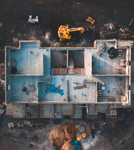 Aerial birds eye image of the frame of a house being built on a construction site at sunset - Wooden floor and walls are visible